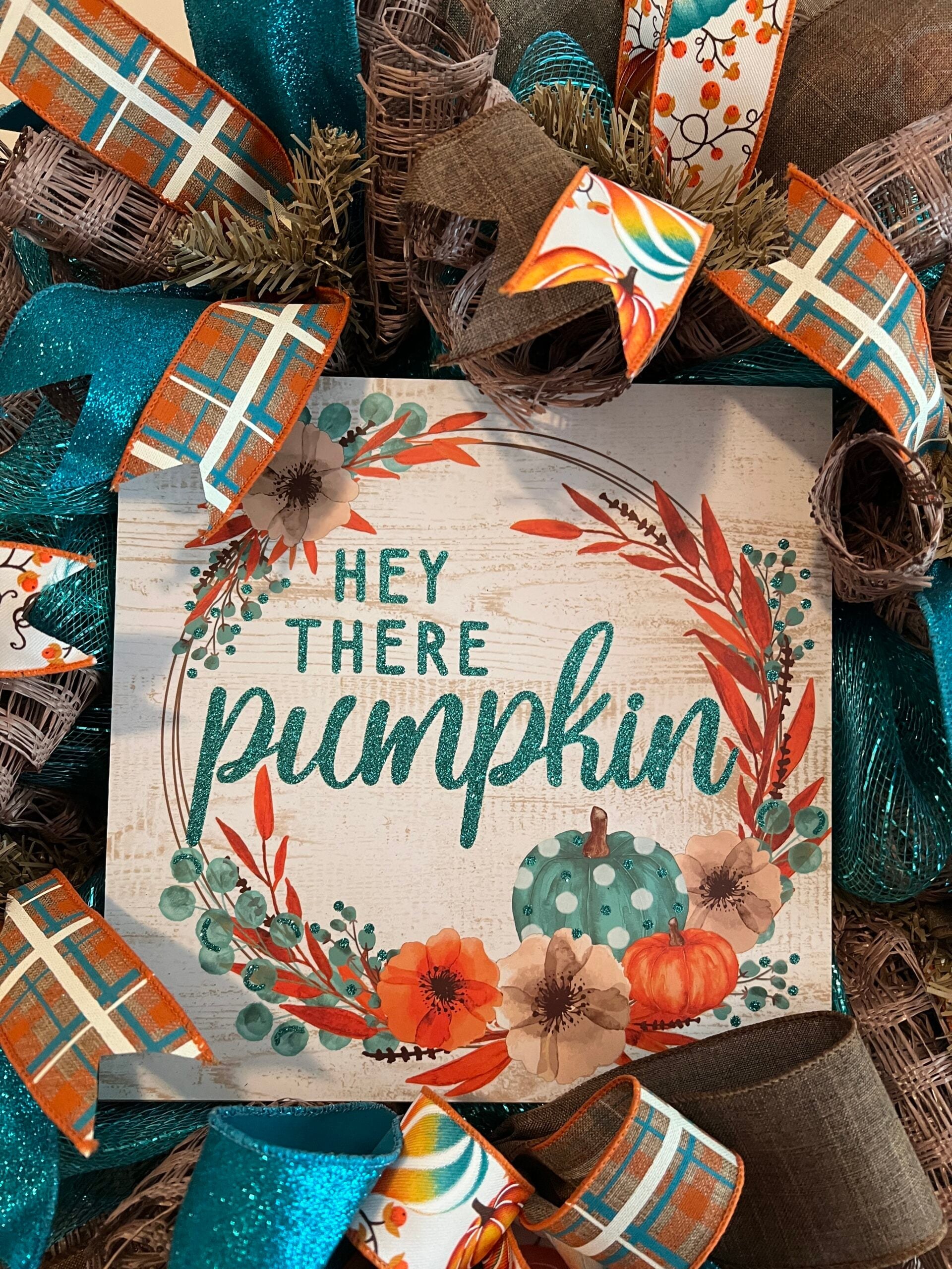 Handmade pumpkin wreath with teal, orange, and plaid ribbon