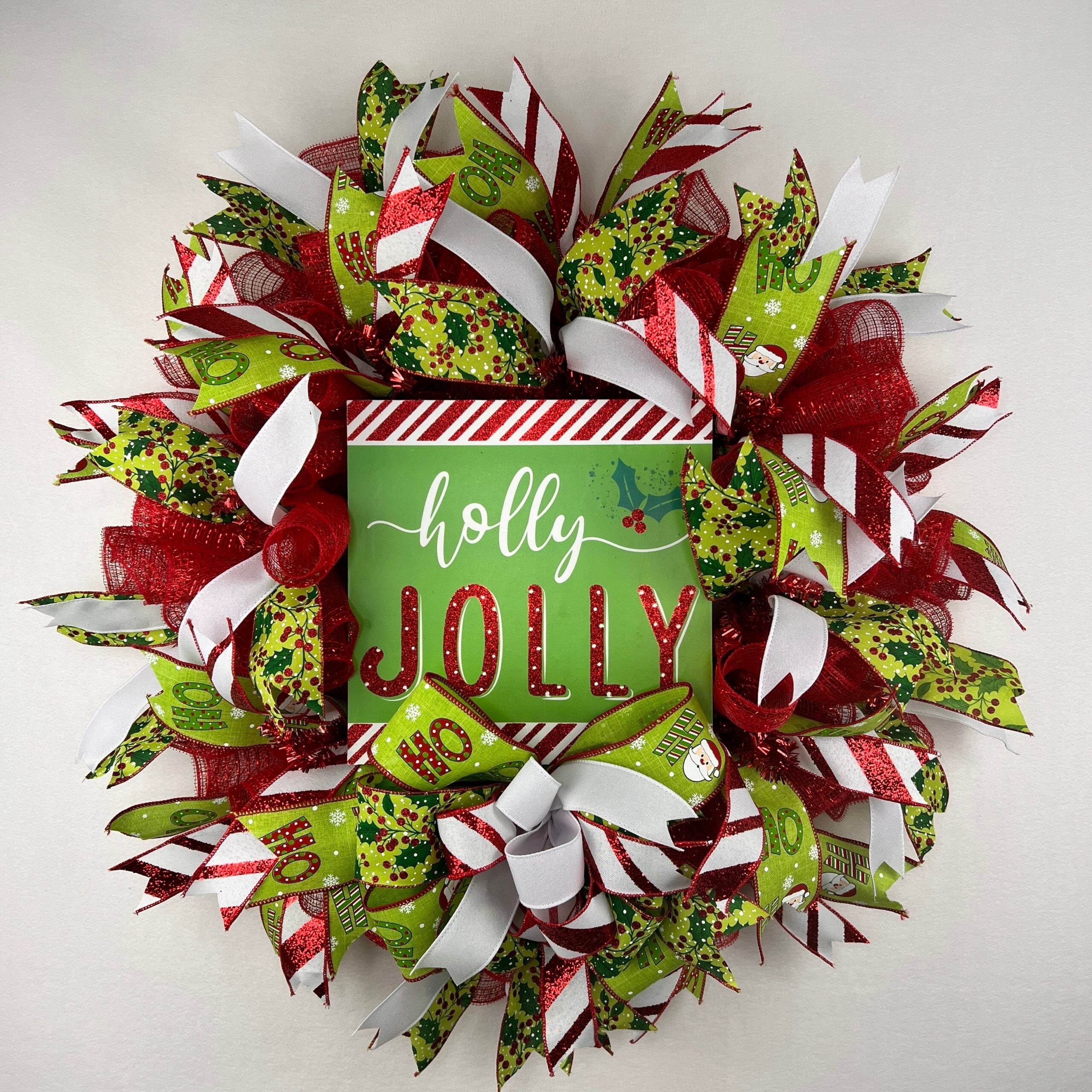 Red deco mesh wreath with a Holly Jolly sign and striped Christmas ribbons