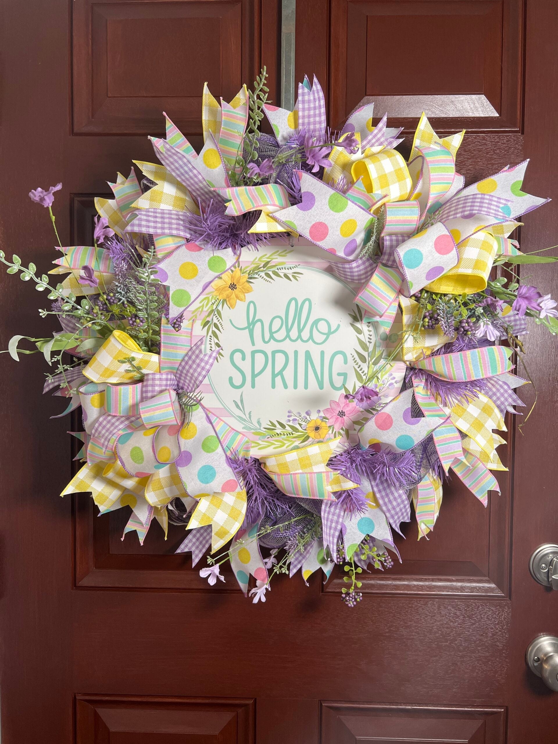 Finished spring deco mesh wreath with pastel mesh, patterned ribbon, and a Hello Spring sign