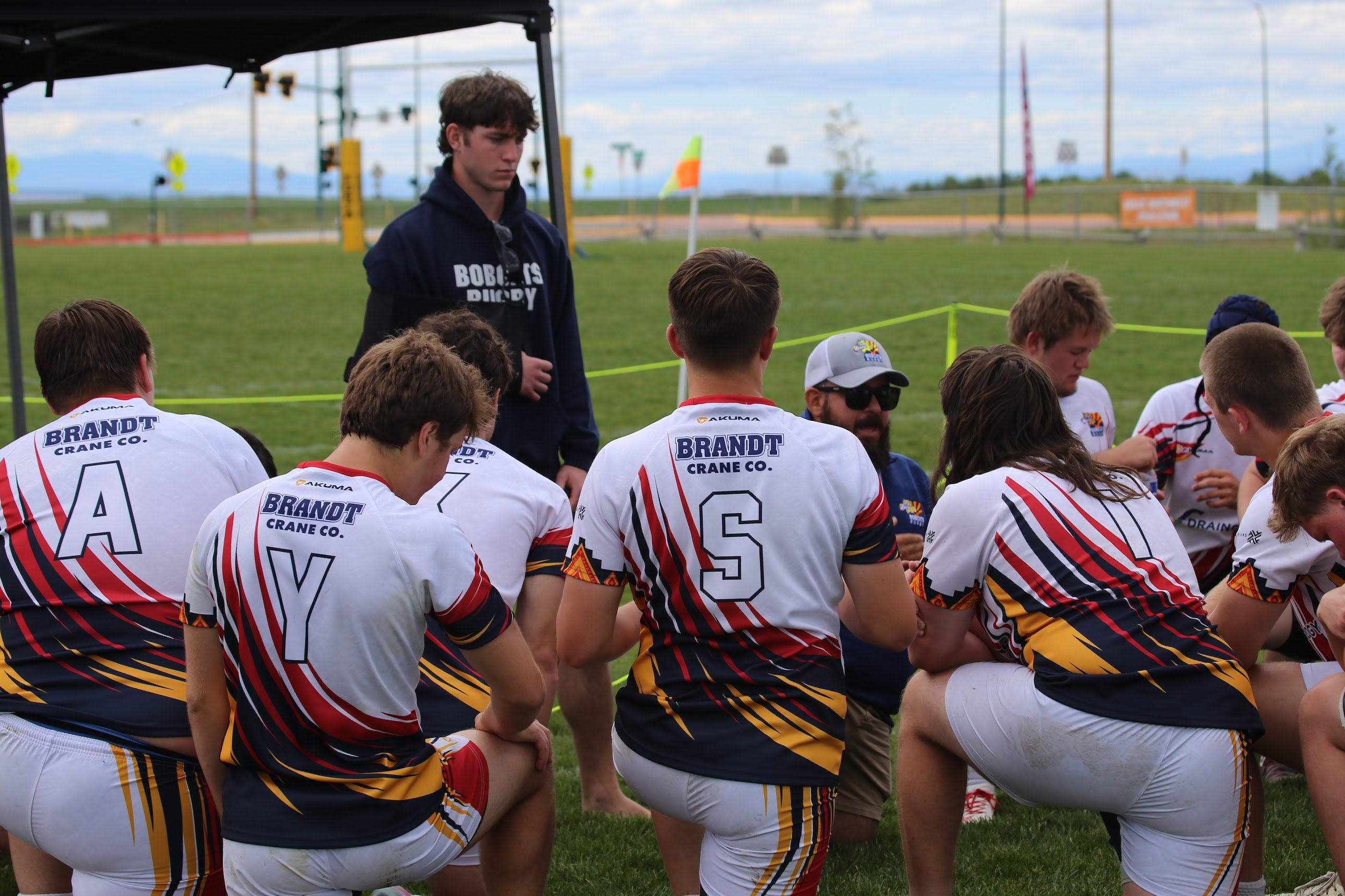 Bobcats players gathered for a team talk beside the rugby field