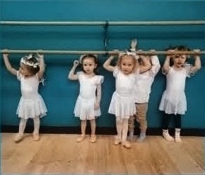 Young DMSD dancers practicing together at the ballet barre