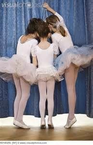 Young ballet friends standing together in white tutus