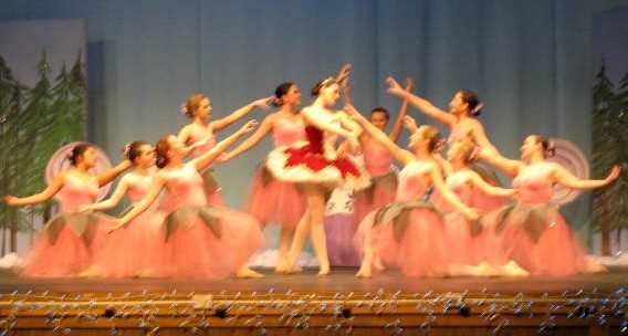 Ballet dancers in peach costumes performing on stage