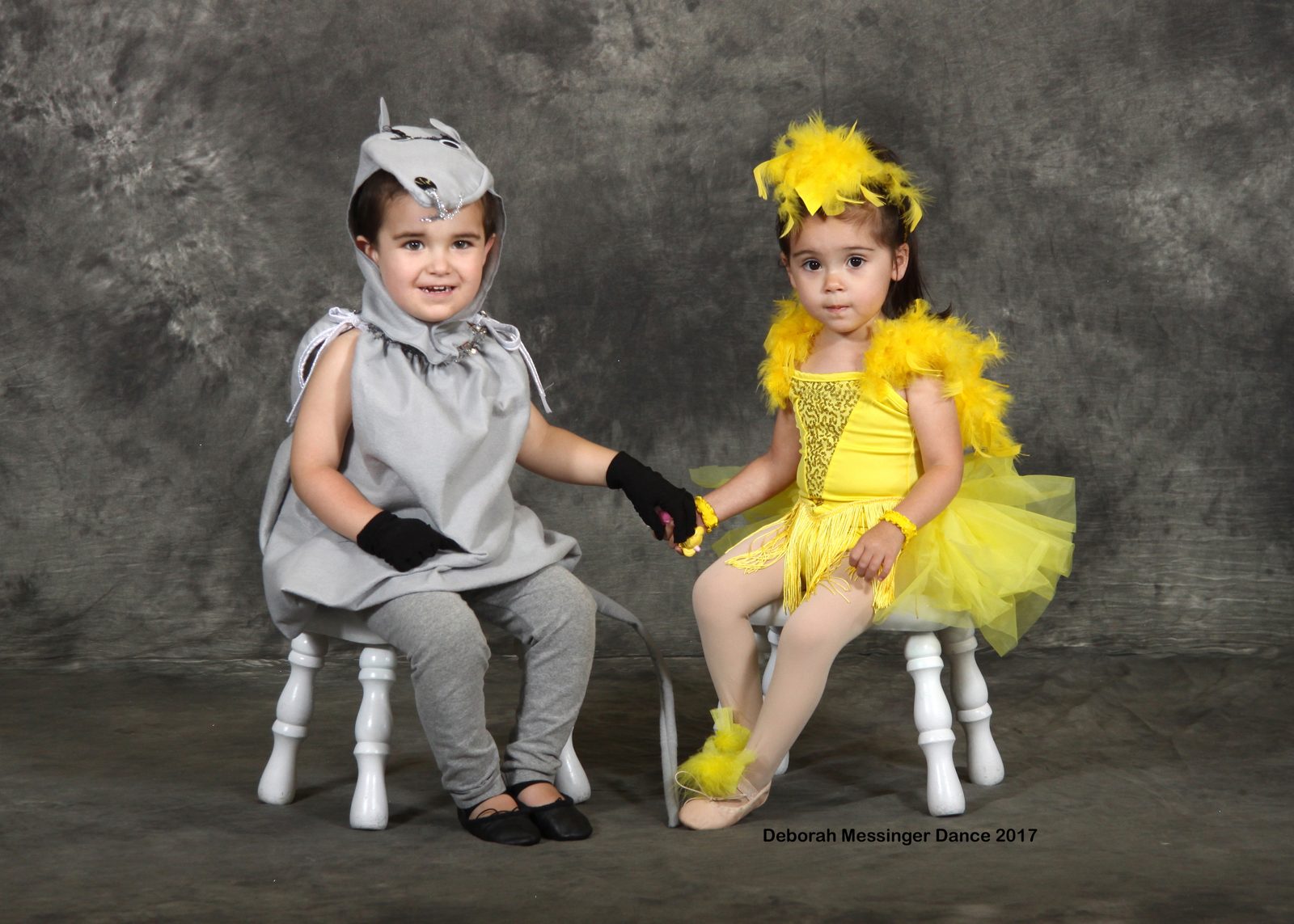 Two young dancers in grey and yellow bird costumes
