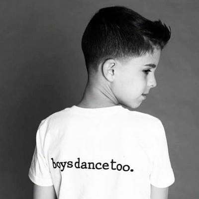 Black-and-white portrait of a boy wearing a Boys Dance Too shirt