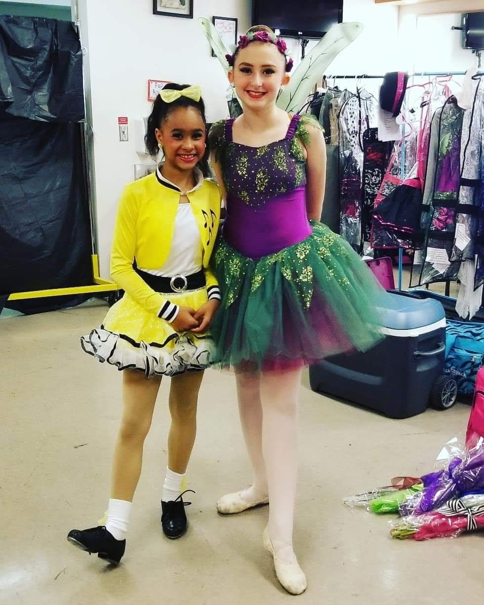 Two DMSD dancers smiling together in colorful costumes