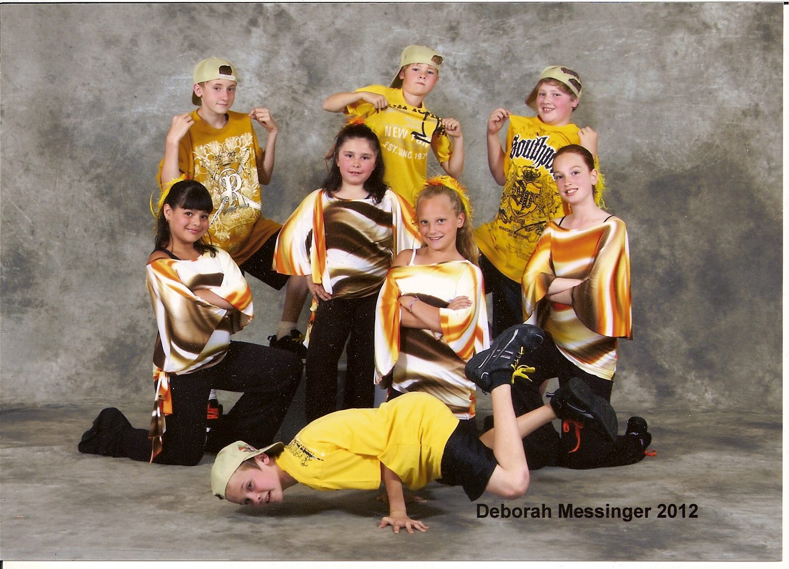 Dance group in coordinated yellow, black, and gold costumes