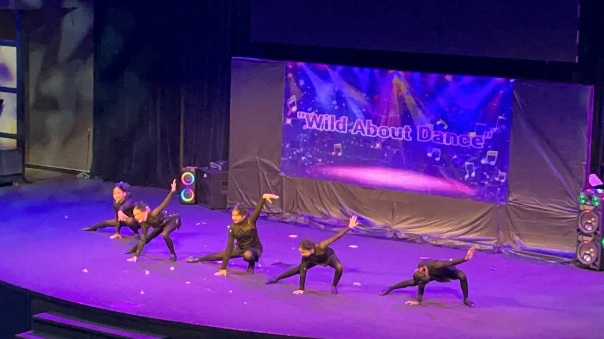 Dancers performing jazz choreography on stage