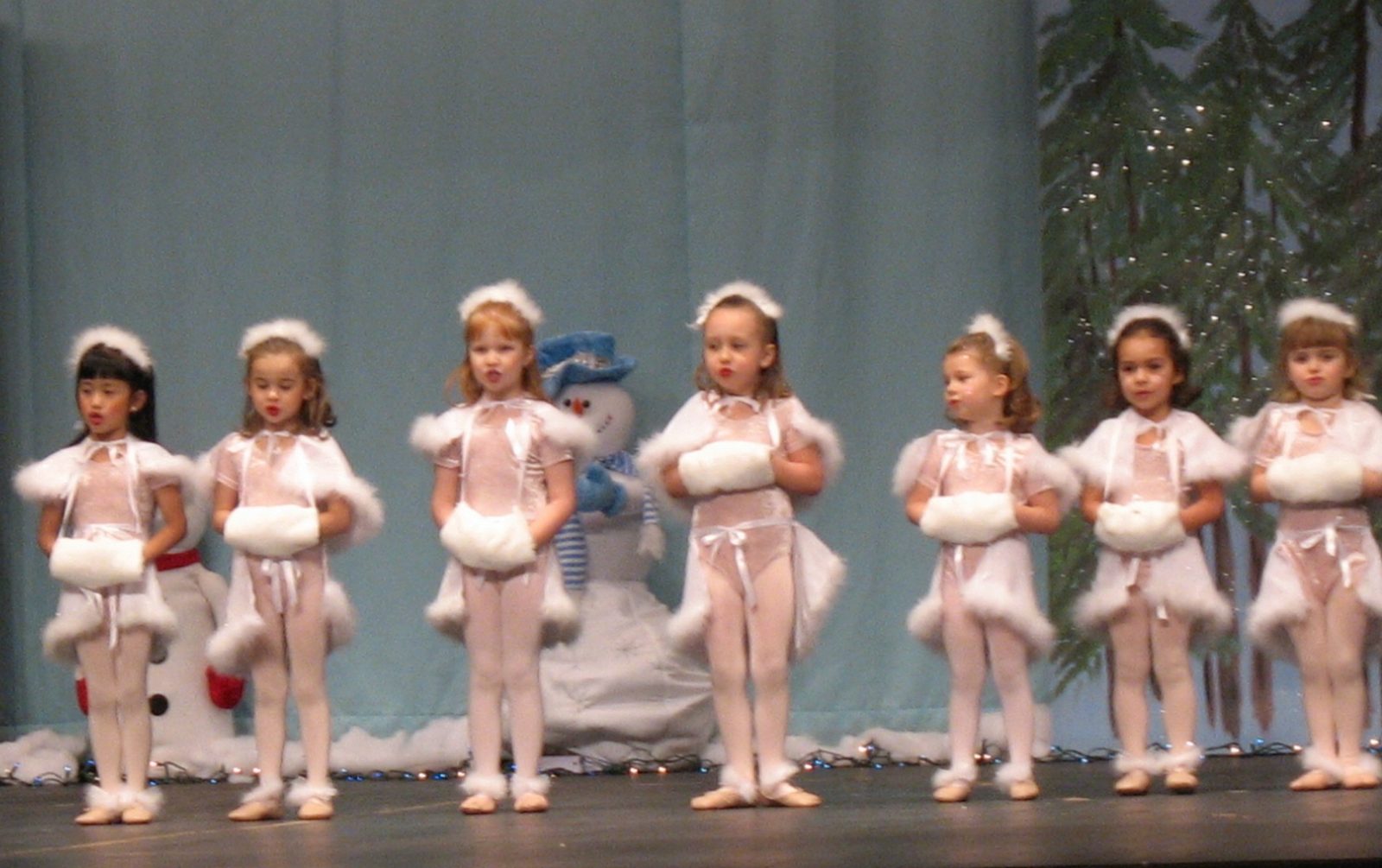 Young dancers in pale pink costumes performing together on stage