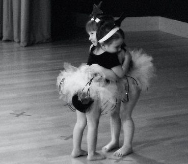 A tiny dancer in a tutu and headband in a black-and-white photograph