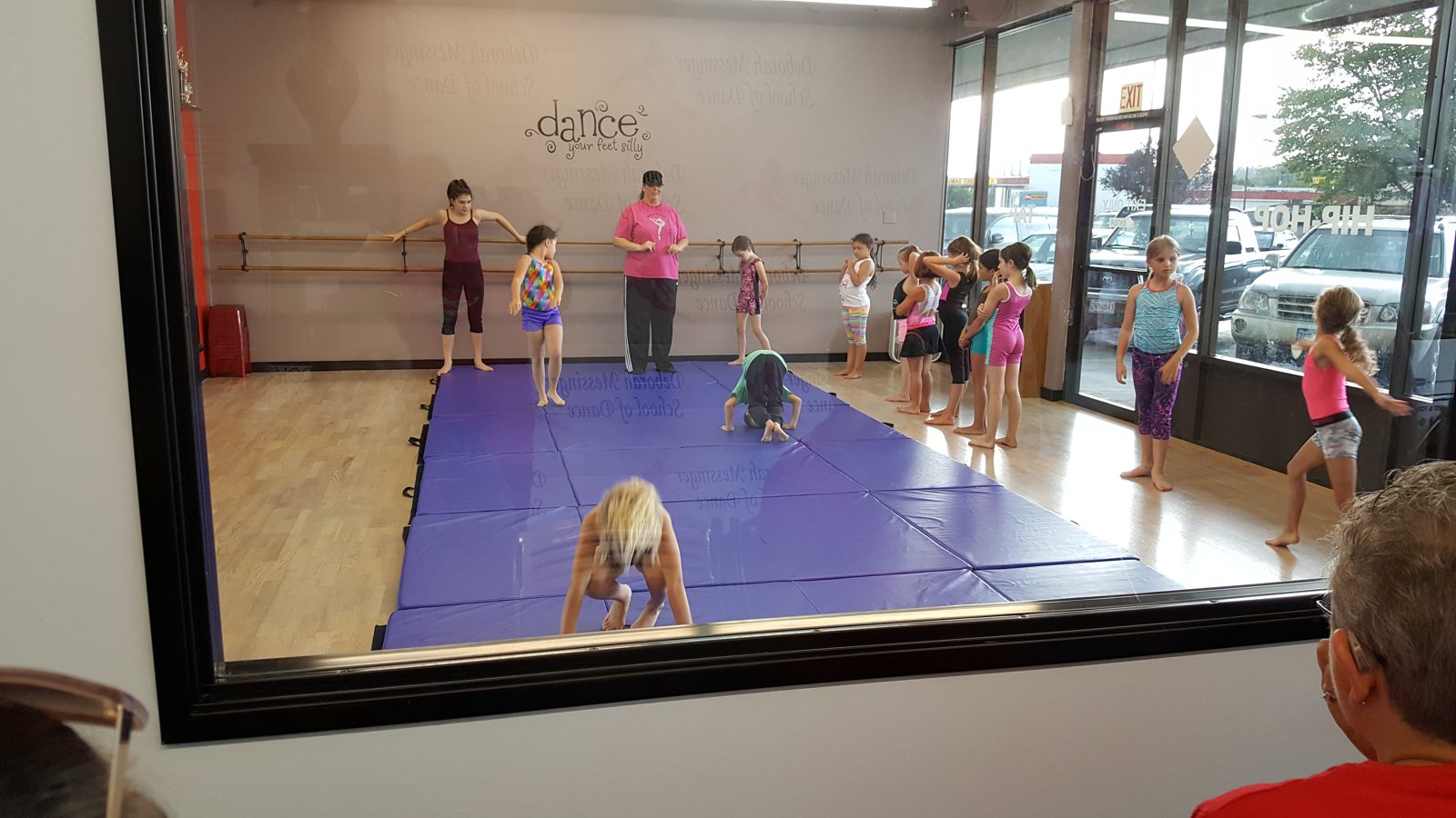 Children practising tumbling on studio mats with their teacher