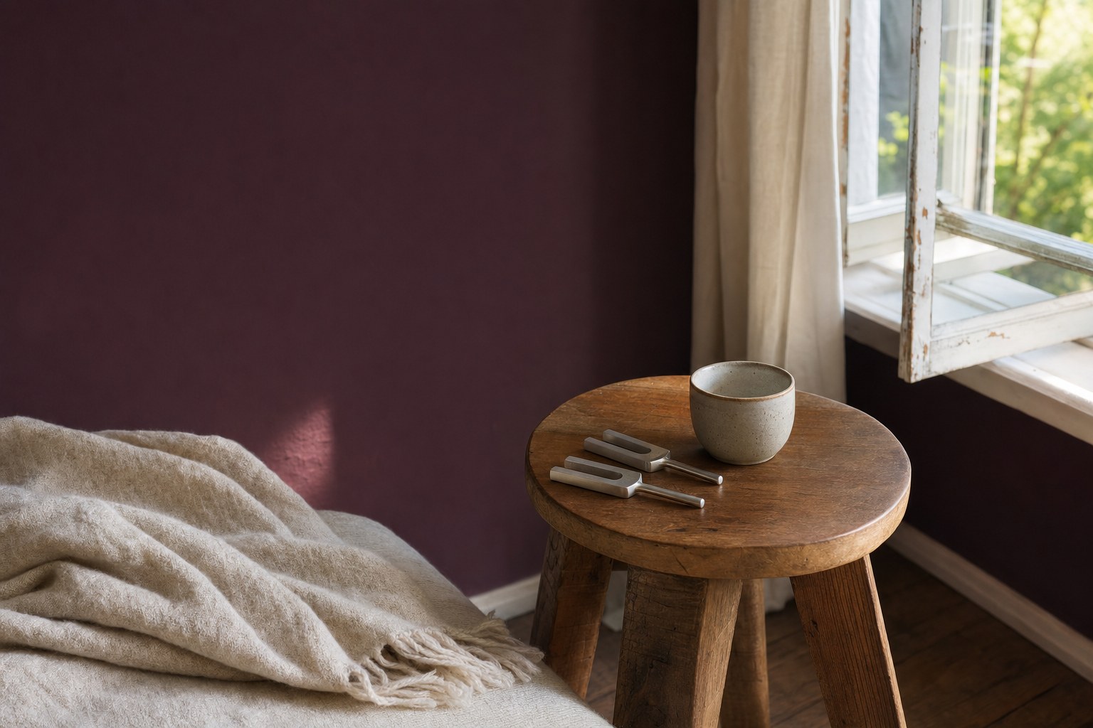 Tuning forks, a ceramic cup, and a folded blanket in a sunlit room