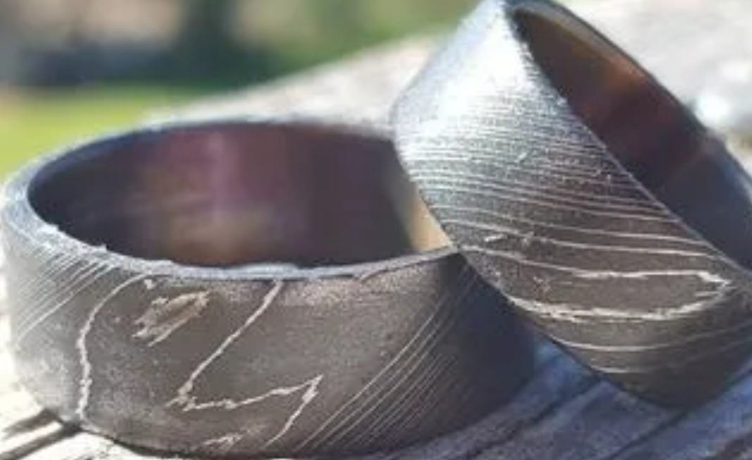 Handmade stainless Damascus steel wedding ring with a flowing forged pattern