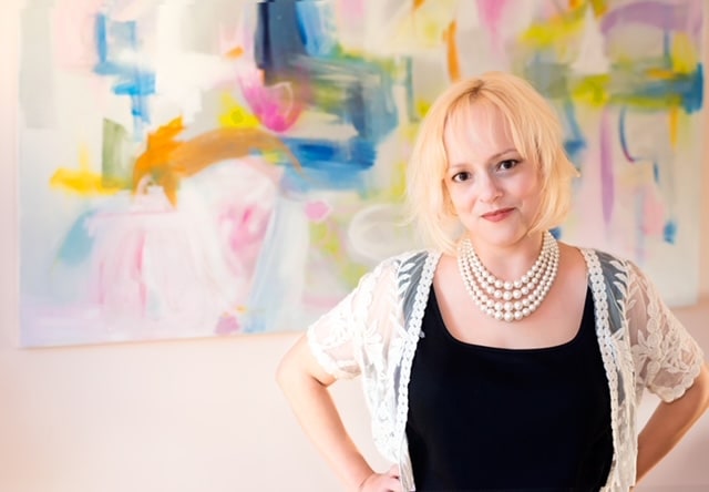 Kerry Steele in her studio in front of an abstract painting