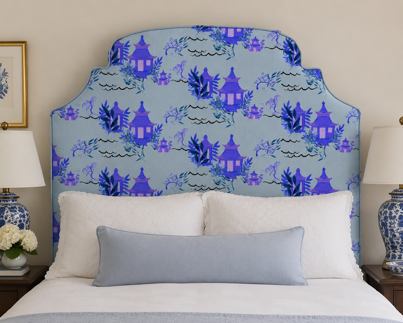 Blue toile wallpaper behind a patterned upholstered headboard