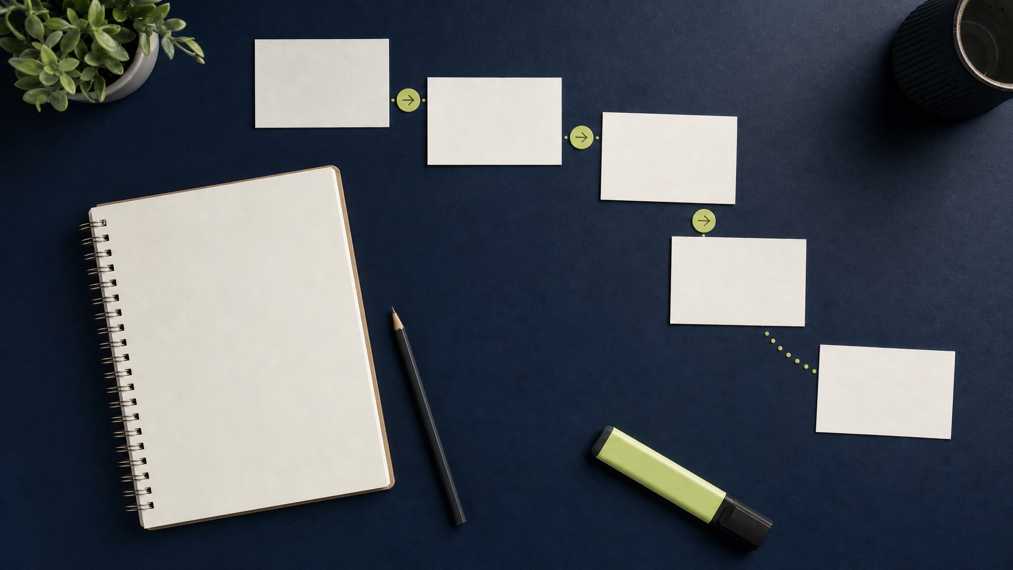Planning notebook and cards arranged as a path across a navy desk