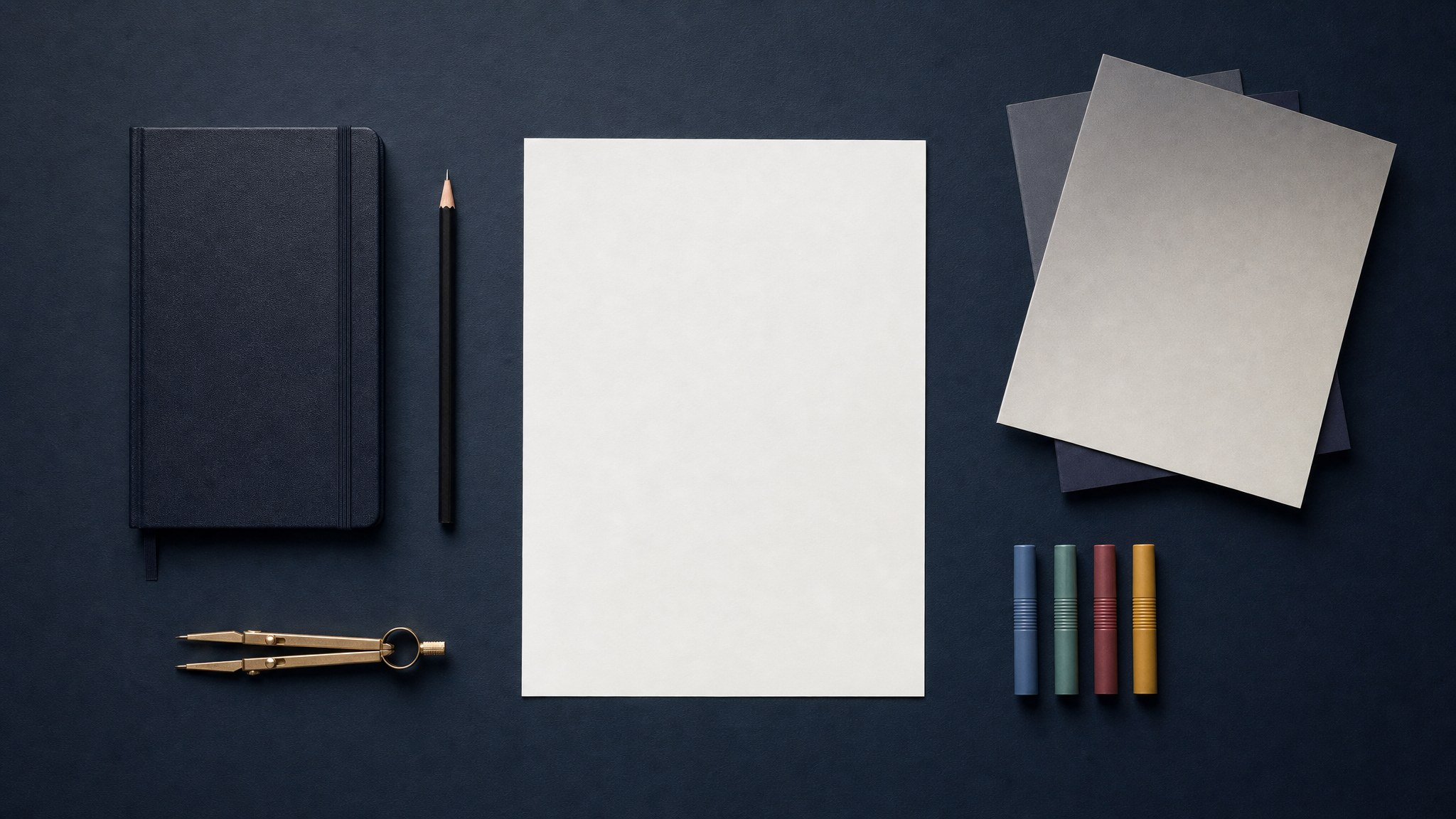 Blank planning sheet, notebook, pencil, and colored markers arranged on a dark navy desk