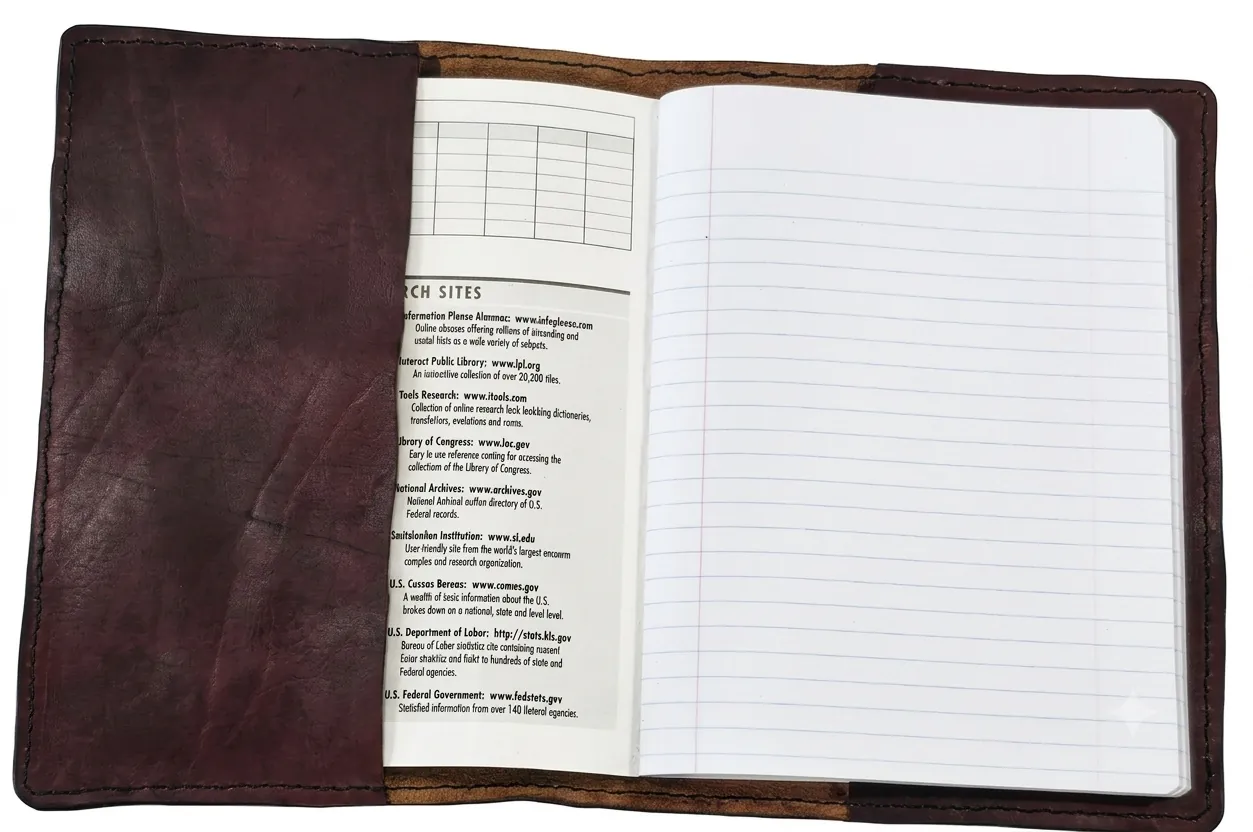 Open dark brown leather journal cover holding a composition notebook