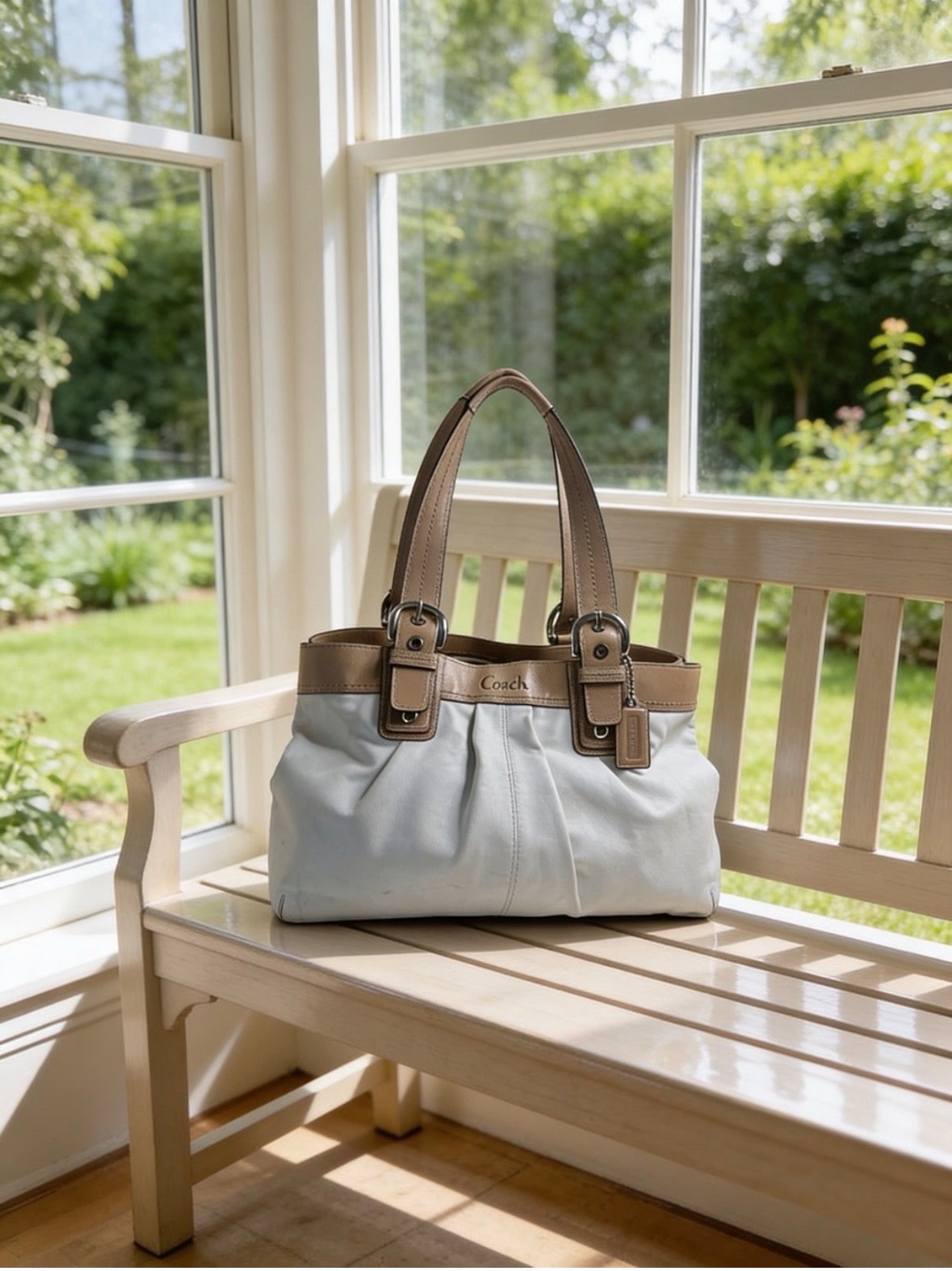 White leather handbag resting on a sunlit bench