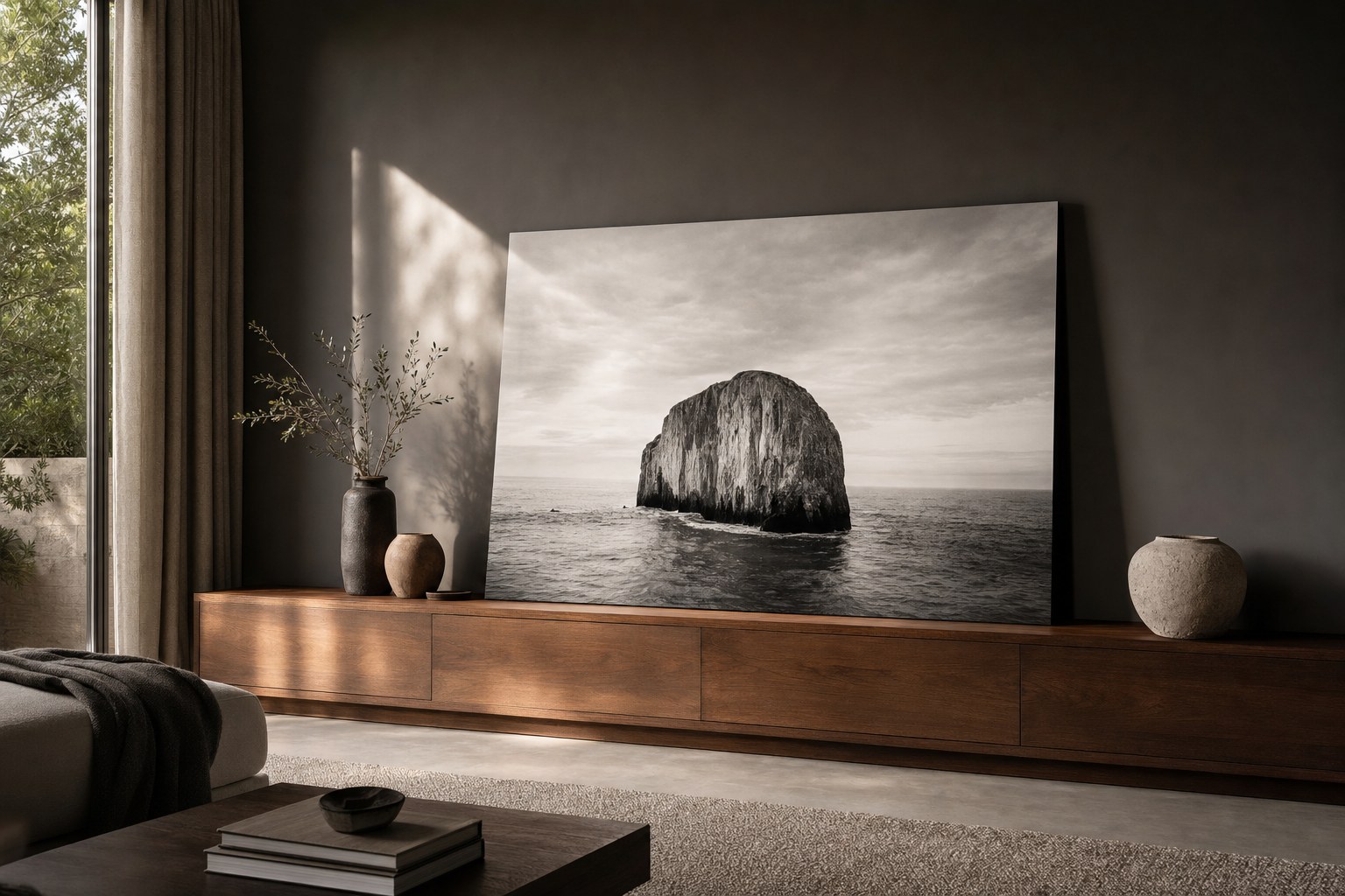 A large black-and-white seascape photograph displayed above a walnut console in a quiet room.