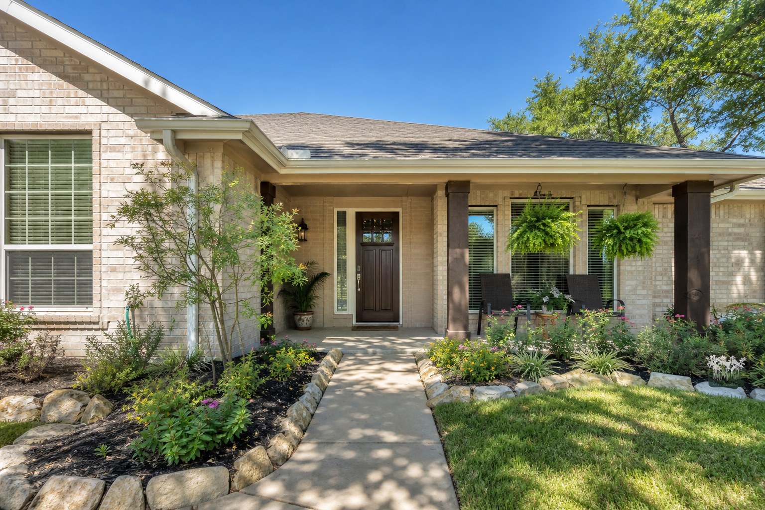 Clean, well-kept Texas home entry with a clear path and maintained planting beds