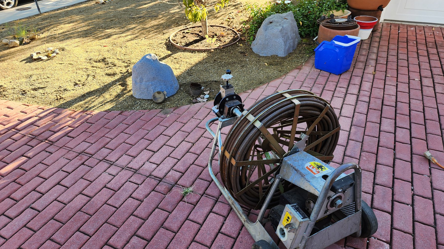Drain cleaning equipment set up on a property walkway