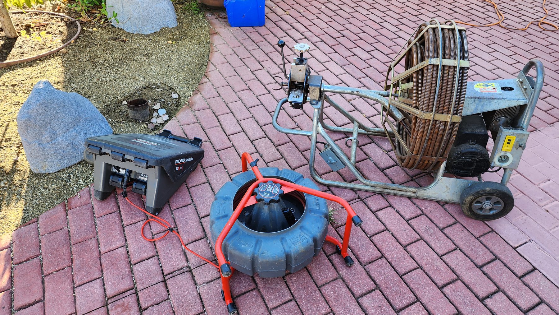Drain cleaning equipment set up beside a property walkway