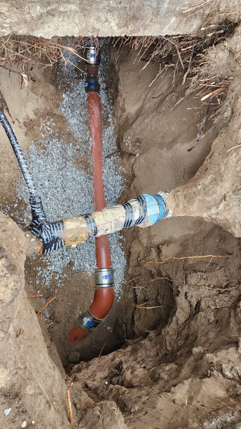 Excavation exposing underground piping for sewer repair