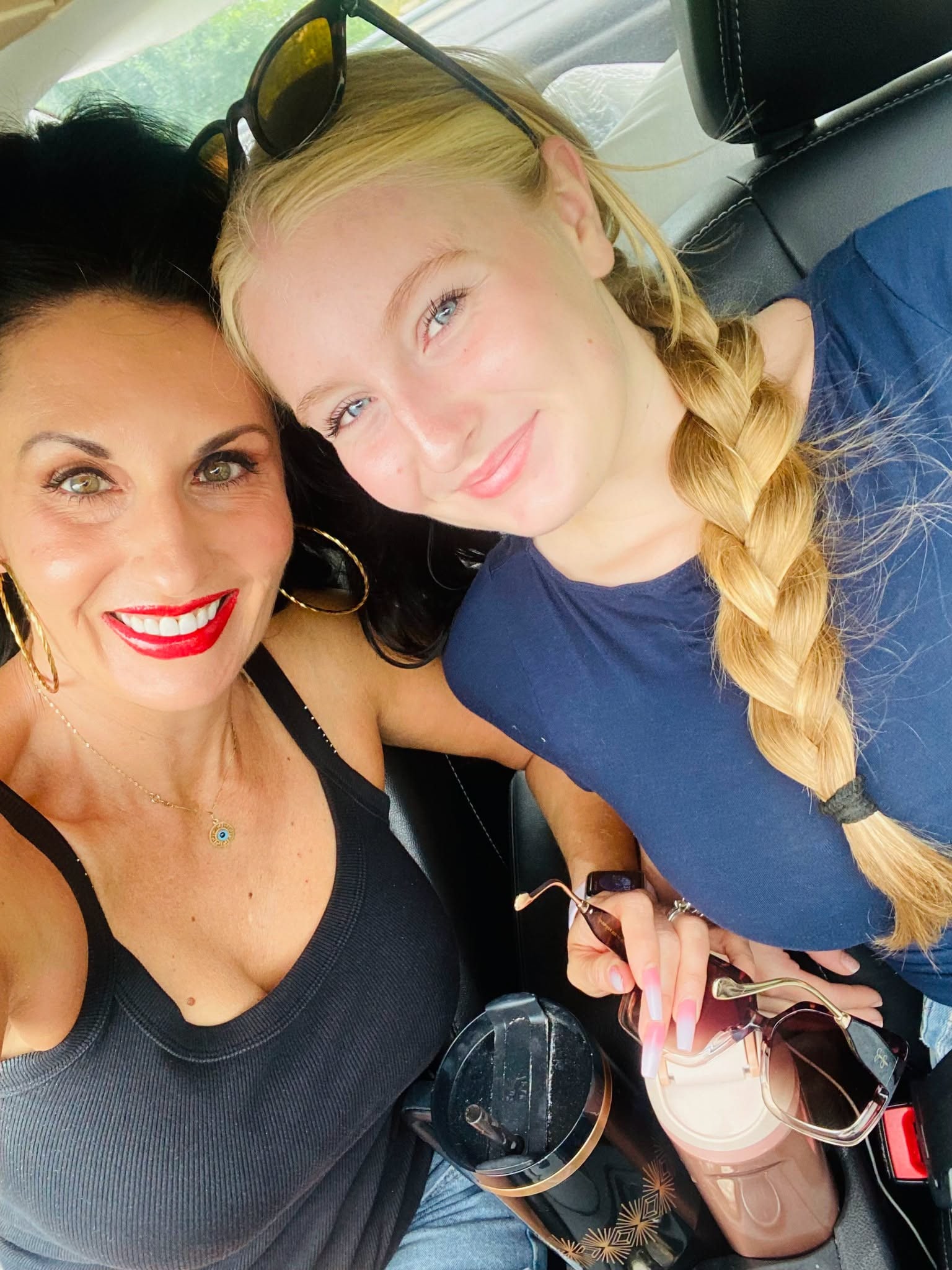 Stacey and her daughter smiling together in the car before college move-in.