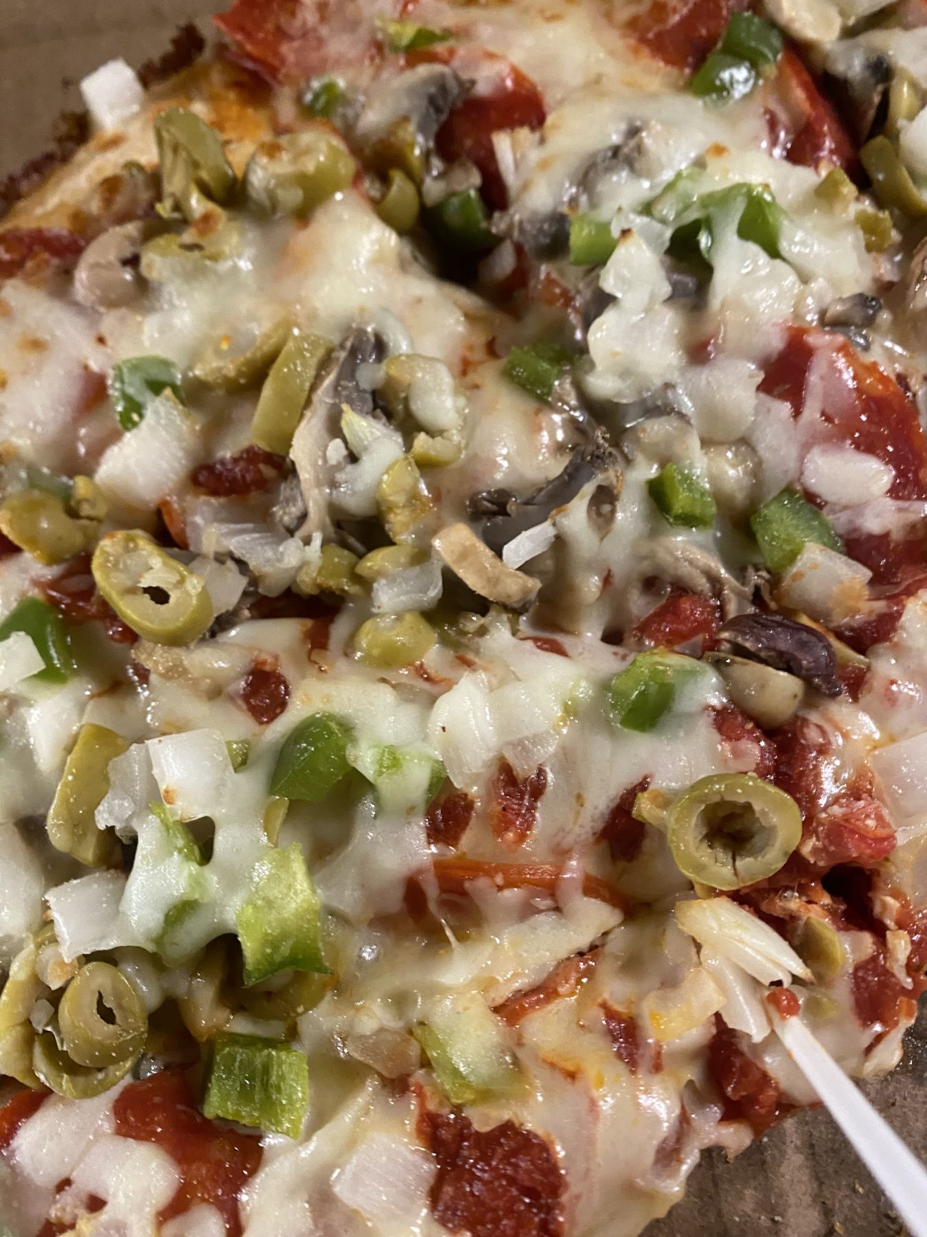 Stacey’s pizza topped with peppers, mushrooms, olives, and cheese.