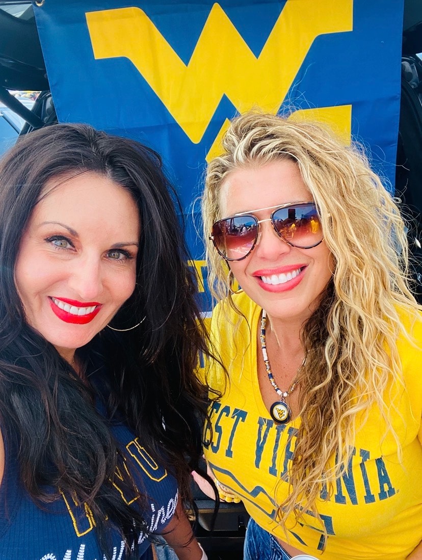 Stacey and a dear friend smiling together at a West Virginia University tailgate.