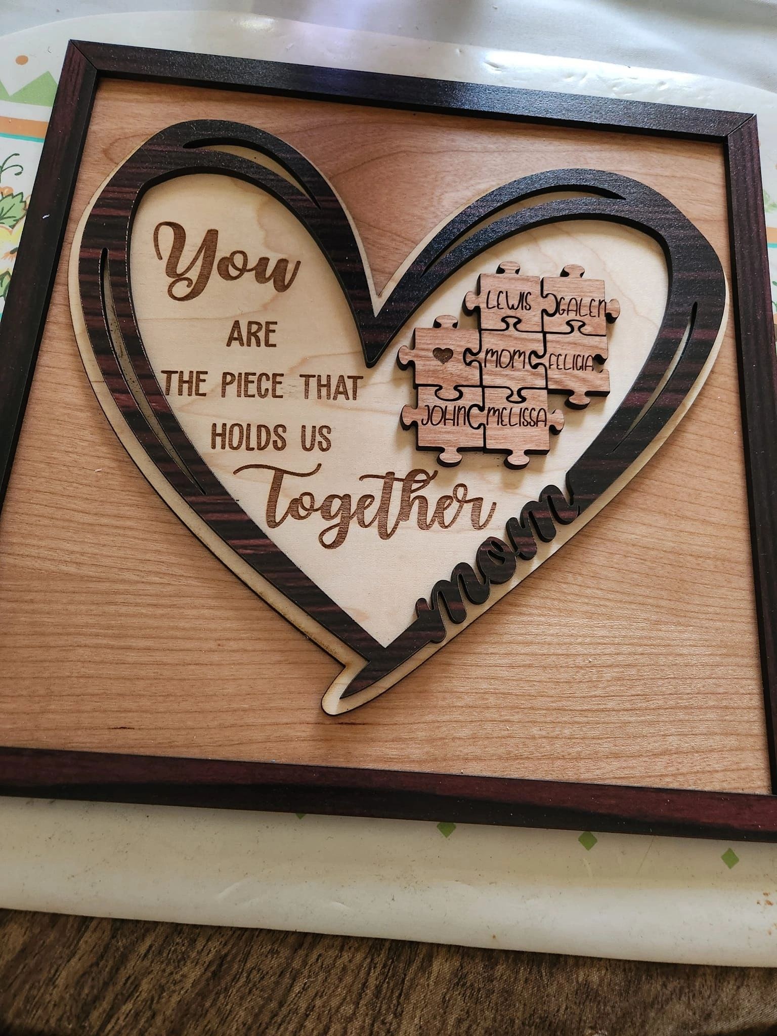 A heart-shaped family puzzle that reads, You are the piece that holds us together, Mom