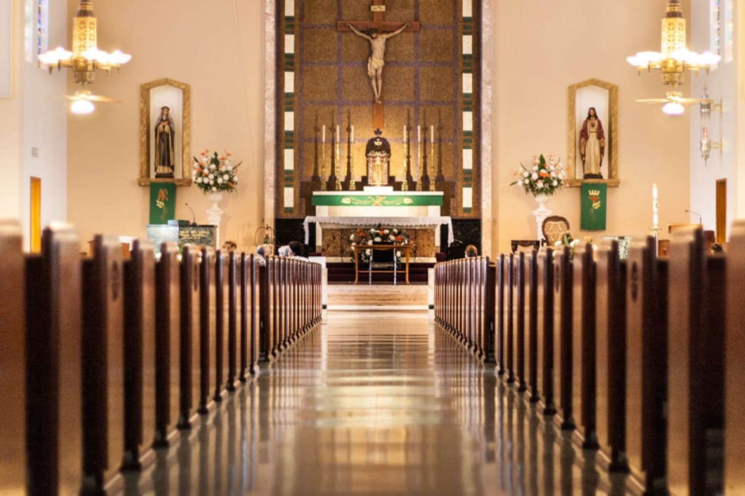 Catholic church nave with wooden pews leading to an altar