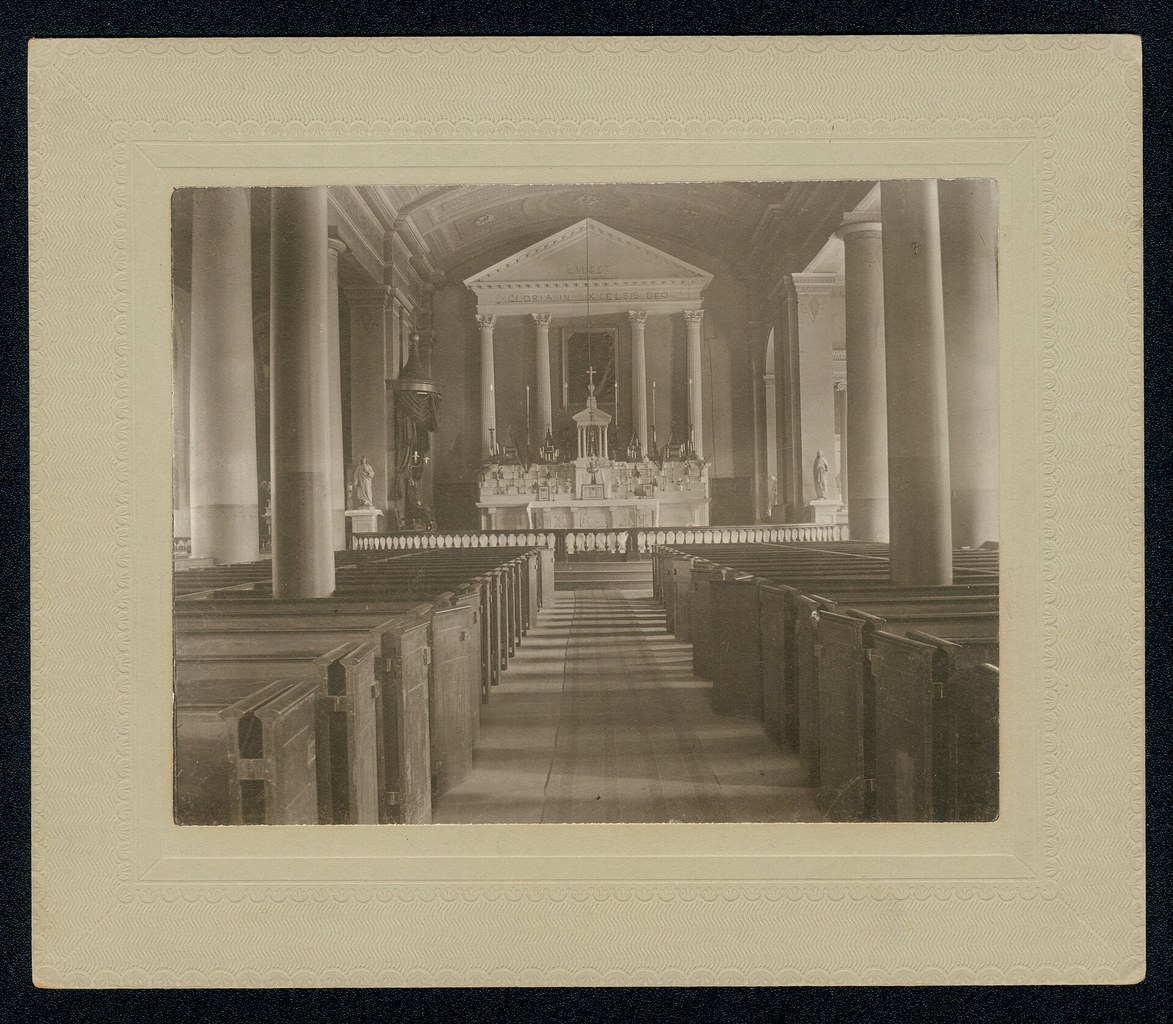 Historic Catholic church interior viewed from the center aisle toward the altar