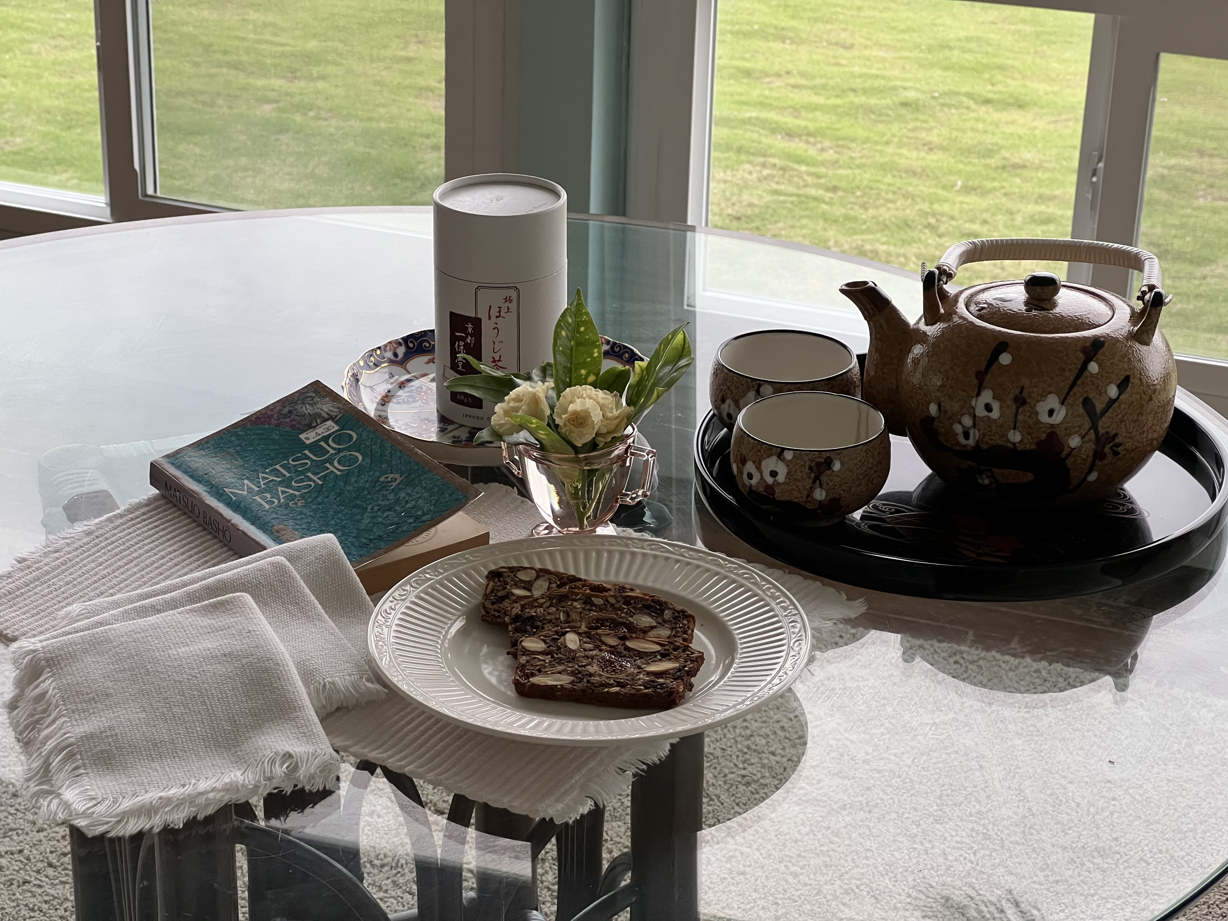 Tea, flowers, and Coastal Crisps on a glass table