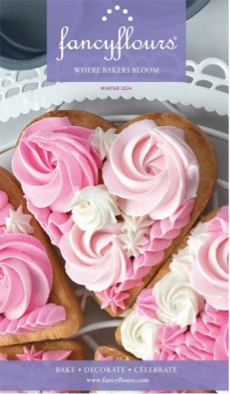 Heart-shaped cookies decorated with pink and white swirled frosting.