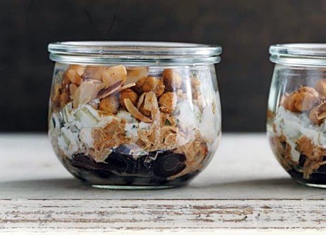 Layered dessert in a glass jar with nuts and chocolate.