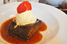 A dessert with vanilla ice cream and strawberry on top.