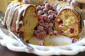 A sliced cranberry cake with icing on a decorative plate.