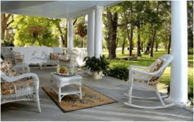 Cozy porch with rocking chairs and a garden view.