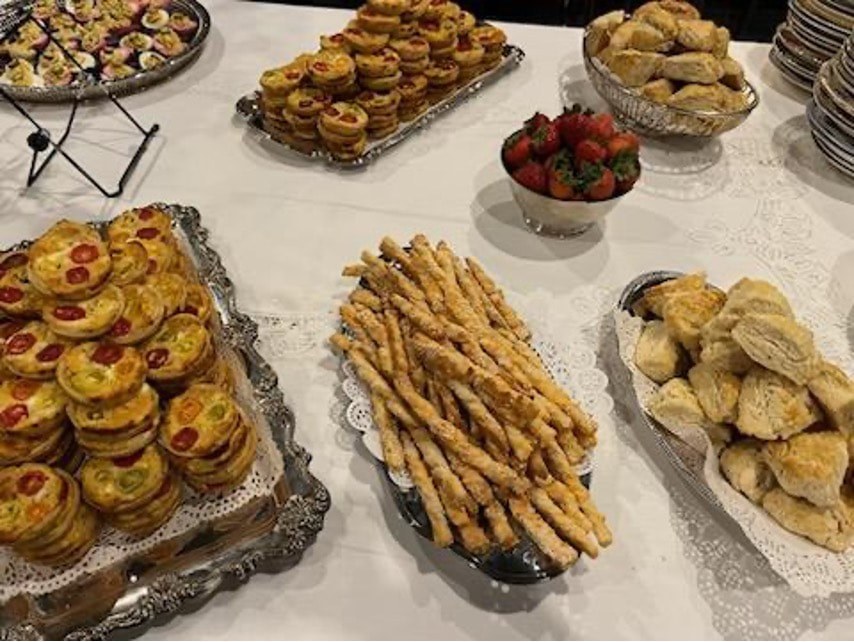 A table with assorted pastries and strawberries arranged on trays.