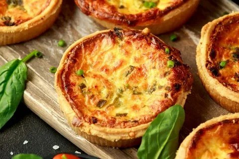 Golden mini quiches with herbs and cheese.