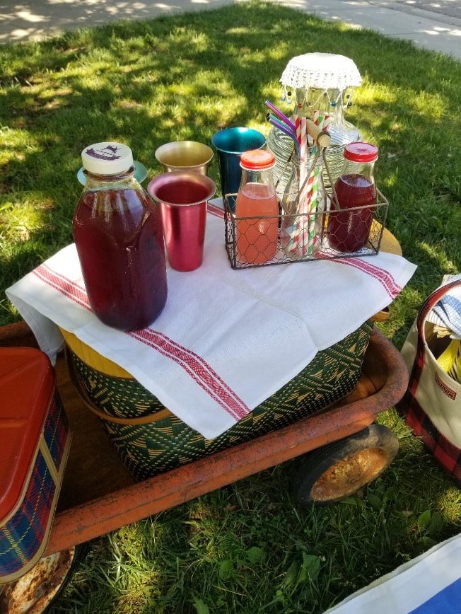 Beverages and condiments on a cloth-covered tray outdoors.