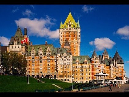 Historic Château Frontenac hotel under a bright blue sky.