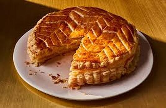 Golden brown pie with a slice cut out on a white plate.