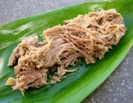 Pulled pork served on a green leaf.