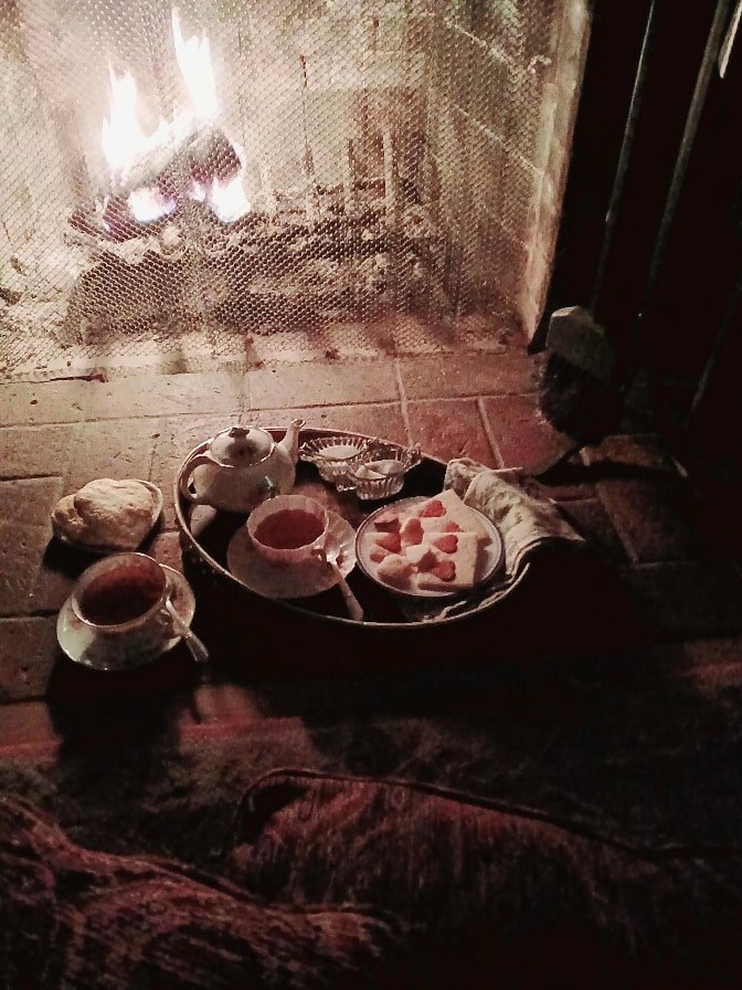 Traditional tea setup with cups and sweets on a rustic table.