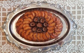 Elegant fruit tart with apricots and figs on a silver platter.