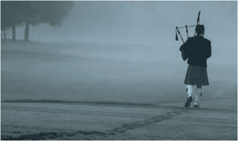 A lone figure walks on a foggy path with a bagpipe.