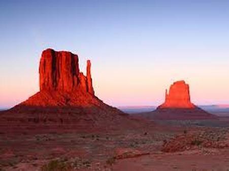 Sunset illuminating Monument Valley's iconic red sandstone buttes.
